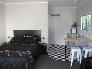 um quarto com uma cama e um lavatório em Cruz Inn em Featherston