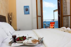 una bandeja de comida en una cama con un plato de comida en Alkyoni Apartments, en Agios Nikolaos
