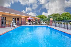a swimming pool in front of a house at Days Inn by Wyndham Moulton in Moulton
