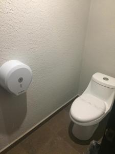 baño con aseo y dispensador de papel higiénico en Intimisimo Autohotel Adults Only Ciudad Industrial en Veracruz