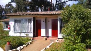 a small house with a red and white door at American Hotel in Los Vilos +1 photo