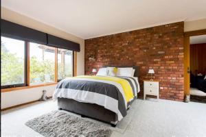 a bedroom with a brick wall and a bed at Adrienne's Country Retreat in Macedon