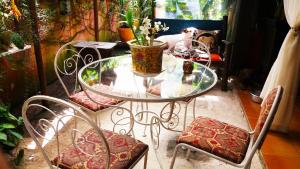 a glass table and chairs with a vase on it at Vila Santa Rosa in Ilhabela
