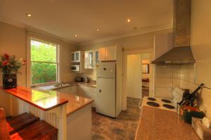 uma cozinha com um frigorífico branco e uma bancada em Grace's Spa Cottage em Smithton