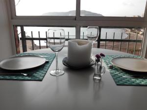 una mesa con dos platos y copas de vino. en El Rinconcito De La Almadraba, en Alicante