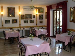a restaurant with pink tables and chairs in a room at Kántás Vendégház Tihany in Tihany