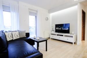 Televízia a/alebo spoločenská miestnosť v ubytovaní Apartament z basenem Polanki