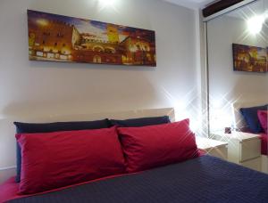 1 dormitorio con 1 cama con almohada roja en San Leonardo House Bologna, en Bolonia