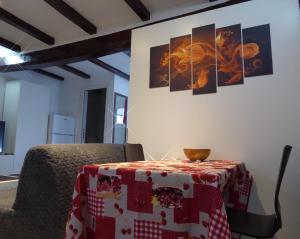 a table with a red and white table cloth on a wall at San Leonardo House Bologna in Bologna