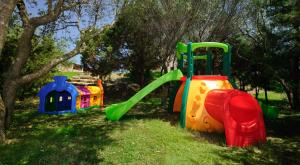 a playground with a slide in the grass at Hotel Baja Bianca in San Teodoro