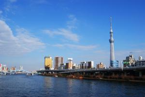 فندق MYSTAYS Asakusa في طوكيو: اطلاله على مدينه بها نهر وجسر