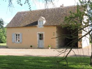 ein kleines gelbes Haus mit einem Dach in der Unterkunft Gîte de La Hertaudière in Montbizot