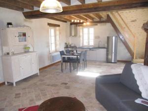 eine Küche und ein Wohnzimmer mit einem Sofa und einem Tisch in der Unterkunft Gîte de La Hertaudière in Montbizot