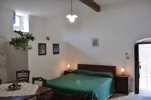 パトゥにあるMasseria San Nicolaのベッドルーム1室(ベッド1台、フルーツプレート付きのテーブル付)