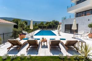 Villa con piscina con sillas y mesa. en White Olive Villa en Herceg-Novi