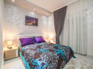 a bedroom with a large bed with purple pillows at Apartments Amigo in Kotor