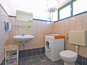ein Badezimmer mit Toilette, Waschbecken und Waschmaschine in der Unterkunft Apartments Duilija 1301 in Barbariga