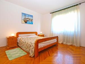ein Schlafzimmer mit einem Bett und einem großen Fenster in der Unterkunft Apartments Duilija 1301 in Barbariga
