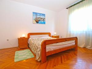 ein Schlafzimmer mit einem Holzbett und einem Fenster in der Unterkunft Apartments Duilija 1301 in Barbariga