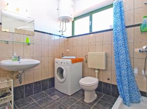 ein Badezimmer mit Waschmaschine und Waschbecken in der Unterkunft Apartments Duilija 1301 in Barbariga + 26 Fotos