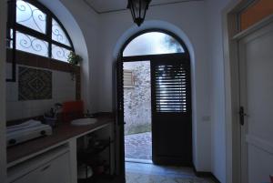 a bathroom with a black door and a sink at Vulcanoconsult Appartamenti Spiaggia in Lipari