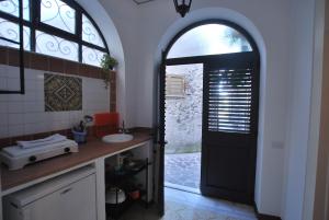 a bathroom with a black door and a sink at Vulcanoconsult Appartamenti Spiaggia in Lipari +34 photos