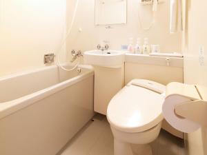 a white toilet sitting next to a bath tub at Hotel Roco Inn Okinawa in Naha