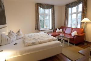 a living room with a bed and a couch at Hotel Restaurant Friedrichs in Nebel