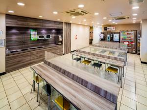 un restaurante de comida rápida con mesas y sillas en Super Hotel JR Shin-Osaka Higashiguchi en Osaka