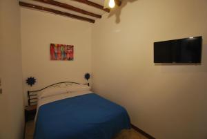a bedroom with a bed and a flat screen tv at Vulcanoconsult Appartamenti Spiaggia in Lipari