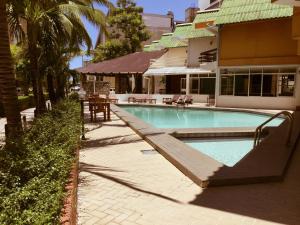 a swimming pool with a ramp leading to a house at Pattaya At Nine in Pattaya