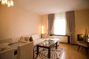 a living room with a couch and a table at Surmeli Istanbul Hotel in Istanbul