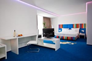 a bedroom with a bed and a desk with a computer at Marshal Garden Hotel in Bucharest