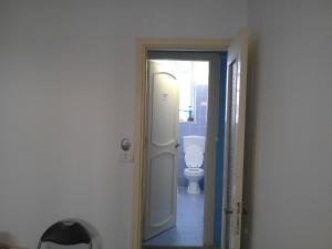 uma casa de banho com um WC branco e um espelho. em I Cinque Continenti em Palermo