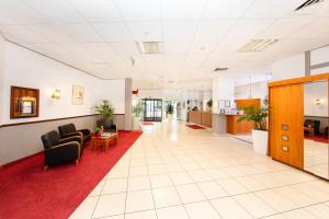 an office lobby with chairs and a red carpet at Montana Parkhotel Marl in Marl