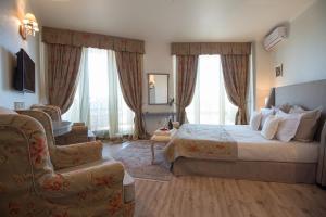 a hotel room with a bed and a chair at Hotel Tempo Boutique in Pazardzhik