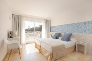 a bedroom with a large bed and a window at Hotel Torá in Paguera