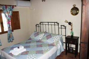 a bedroom with a bed with a quilt on it at Casa Rural El Quinto y Medio in Valdelacasa de Tajo