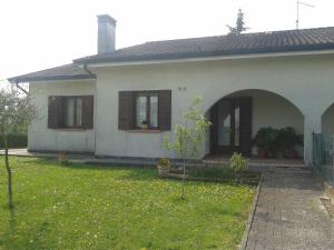 een wit huis met bruine ramen en een tuin bij Locazione Turistica alle Tre Civette in Noale