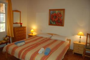 a bedroom with a bed with blue flip flops on it at Casa el Anden in El Cedro