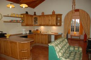a kitchen with wooden cabinets and a counter top at Casa el Anden in El Cedro