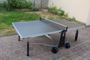 a ping pong table sitting on a brick ground at La Bergerie du festel in Saint-Riquier