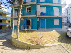 a blue house with a tree in front of it at Condominio Sole - Agenzia Cocal in Caorle