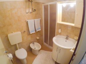 a bathroom with a sink and a toilet and a shower at Condominio Sole - Agenzia Cocal in Caorle