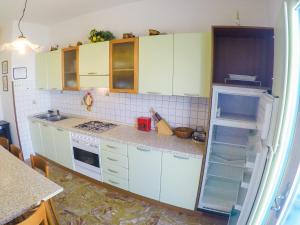 a kitchen with white cabinets and an open refrigerator at Condominio Sole - Agenzia Cocal in Caorle +6 photos