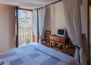 a bedroom with a bed and a computer on a desk with a window at Casa rural Restaurante Aranburu in Zestoa