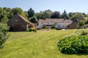 a large yard with houses in the background at Pardlestone Farm Cottages in Kilve