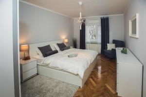 una camera con un letto bianco e un computer portatile di Green Avenue Apartment Zagreb a Zagabria