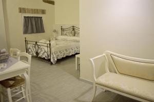 CalossoにあるL'Antico Fienileのベッド2台、テーブル、椅子が備わる客室です。