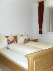 a white couch with pillows on it with a window at Leirerfeld in Alpbach